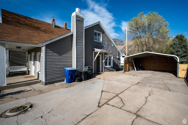 204 S 500 E, Ogden, UT 84404 - view of side of property featuring a detached carport, a chimney, and concrete driveway