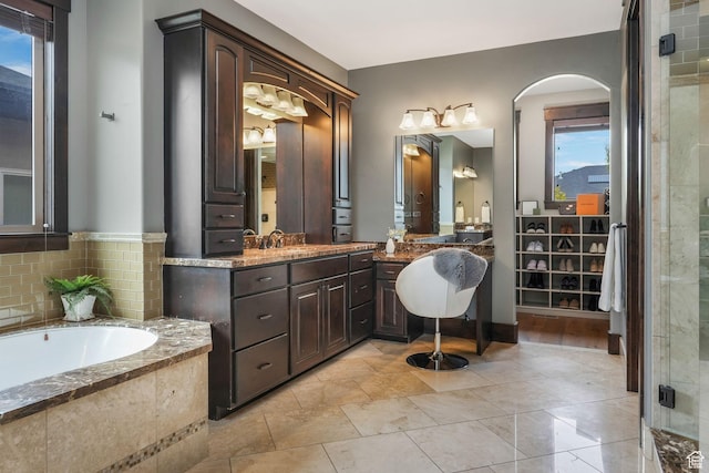 bathroom featuring a bath, vanity, and a stall shower