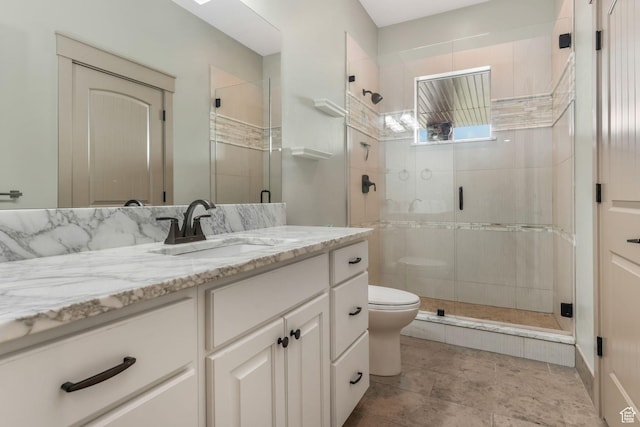 bathroom featuring a stall shower, vanity, and toilet