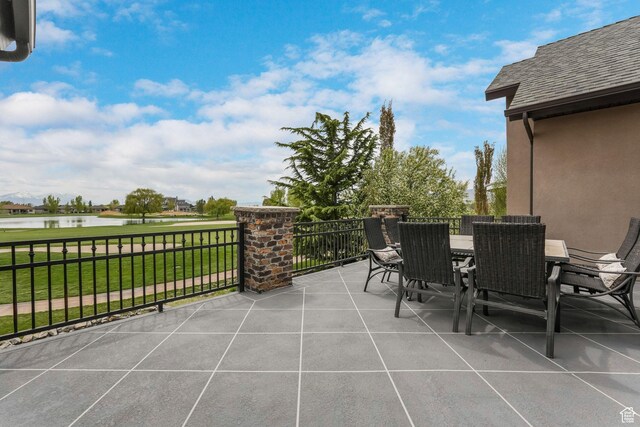 view of patio with a water view and outdoor dining space