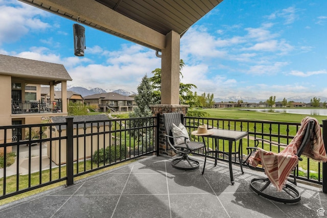 balcony with a water and mountain view, view of golf course, and a residential view
