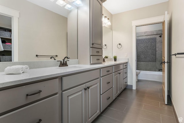 full bath featuring toilet, tile patterned flooring, a sink, and double vanity