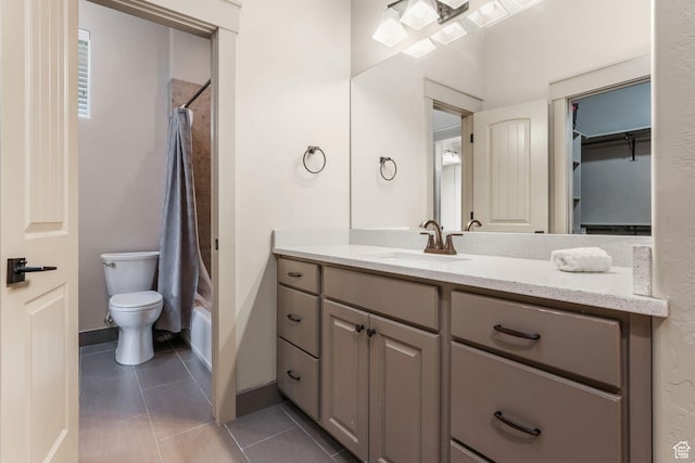 bathroom with toilet, vanity, tile patterned floors, and baseboards