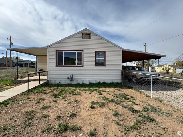 150 Berkley Ave, East Carbon, UT 84520 - view of side of home featuring driveway, fence, and an attached carport