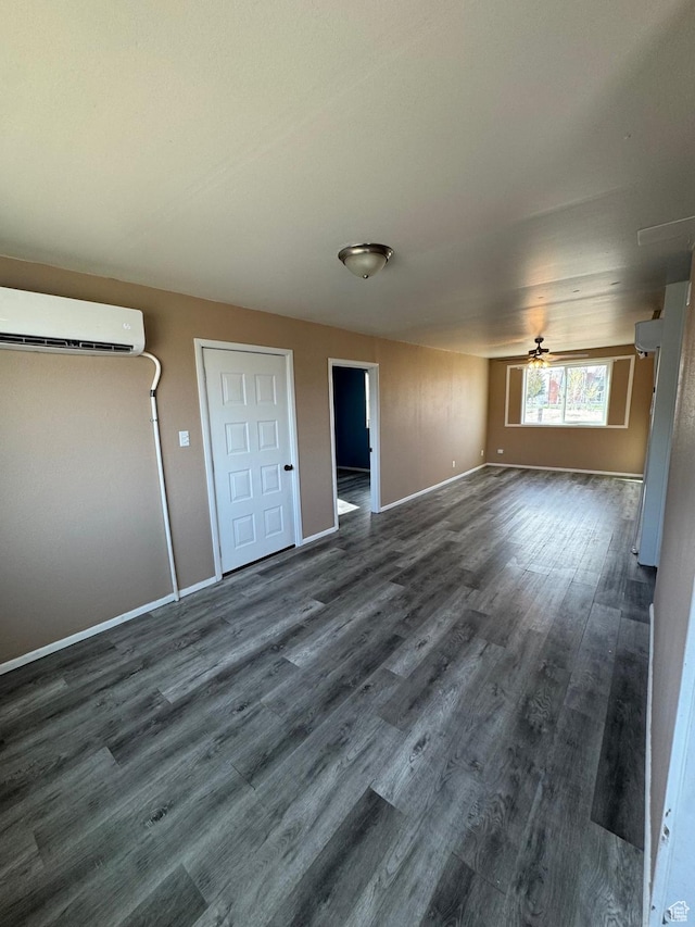 150 Berkley Ave, East Carbon, UT 84520 - empty room with a wall mounted air conditioner, baseboards, and dark wood-style flooring