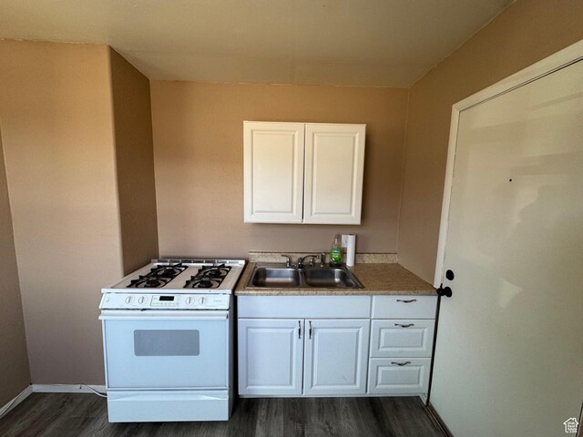 150 Berkley Ave, East Carbon, UT 84520 - kitchen featuring a sink, white cabinets, white range with gas stovetop, dark wood finished floors, and baseboards