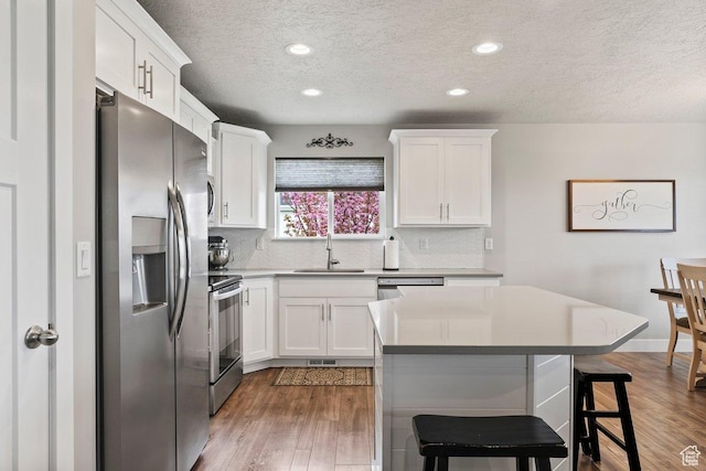 1795 N 4475 W, Plain City, UT 84404 - kitchen featuring a textured ceiling, white cabinetry, stainless steel appliances, and a sink