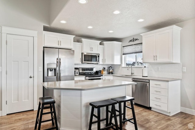 1795 N 4475 W, Plain City, UT 84404 - kitchen featuring white cabinets, decorative backsplash, stainless steel appliances, and a sink