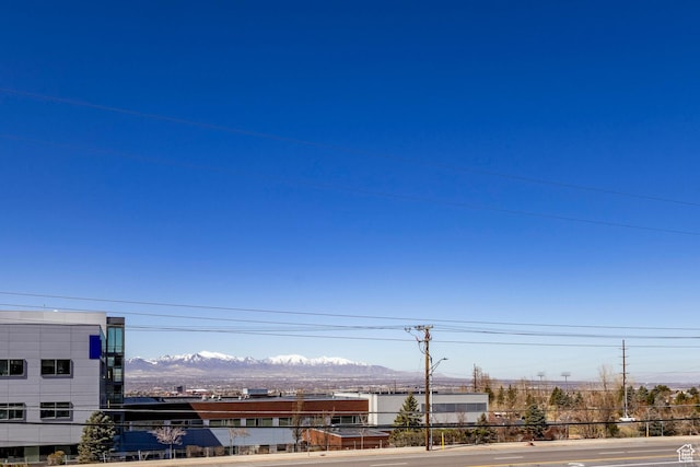 9466 S Indian Ridge Dr E, Sandy, UT 84092 - view of asphalt road featuring street lighting, a mountain view, curbs, and sidewalks
