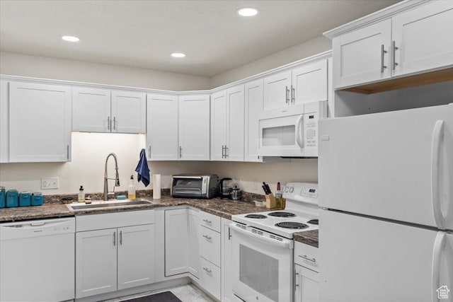 kitchen with a toaster, a sink, dark countertops, white cabinetry, and white appliances