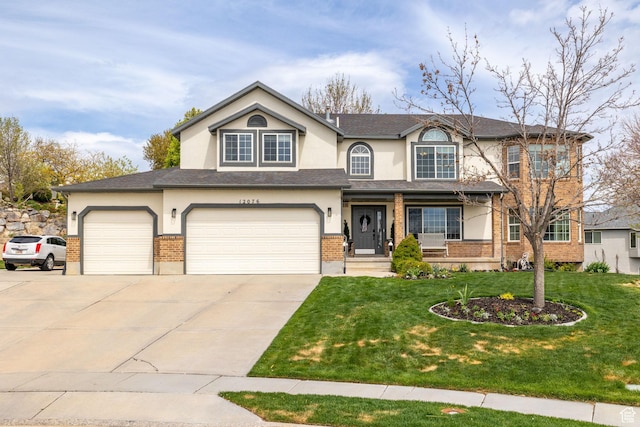 traditional home featuring a front lawn, a porch, concrete driveway, brick siding, and stucco siding