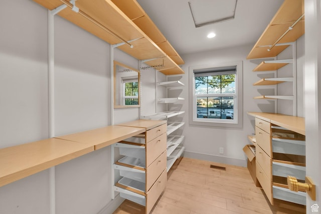 spacious closet featuring light wood-type flooring, attic access, and visible vents