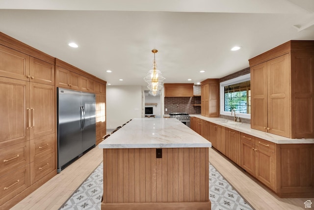 kitchen featuring recessed lighting, light wood-type flooring, a kitchen island, and appliances with stainless steel finishes