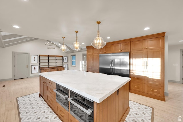 kitchen with recessed lighting, light countertops, stainless steel built in fridge, and a kitchen island