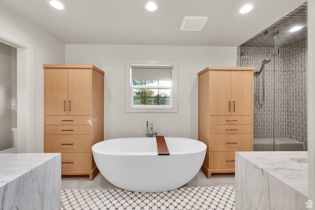 full bathroom featuring tile patterned flooring, recessed lighting, a freestanding tub, and a stall shower