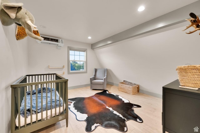 bedroom featuring wood finished floors, an AC wall unit, and recessed lighting