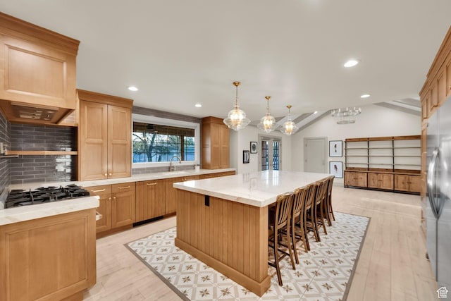 kitchen featuring recessed lighting, a kitchen island, light wood-style floors, and tasteful backsplash