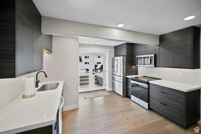 2848 S Preening Way, Saratoga Springs, UT 84045 - kitchen featuring appliances with stainless steel finishes, a sink, modern cabinets, light wood-style floors, and recessed lighting