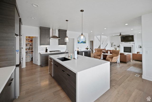 2848 S Preening Way, Saratoga Springs, UT 84045 - kitchen featuring wall chimney range hood, a sink, modern cabinets, light countertops, and tasteful backsplash