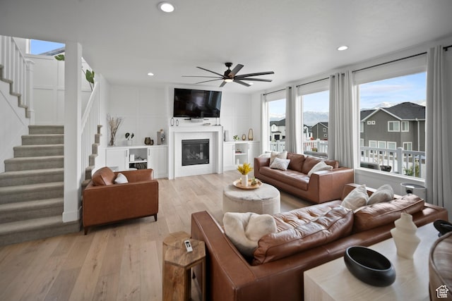 2848 S Preening Way, Saratoga Springs, UT 84045 - living area with light wood-type flooring, ceiling fan, stairway, recessed lighting, and a glass covered fireplace