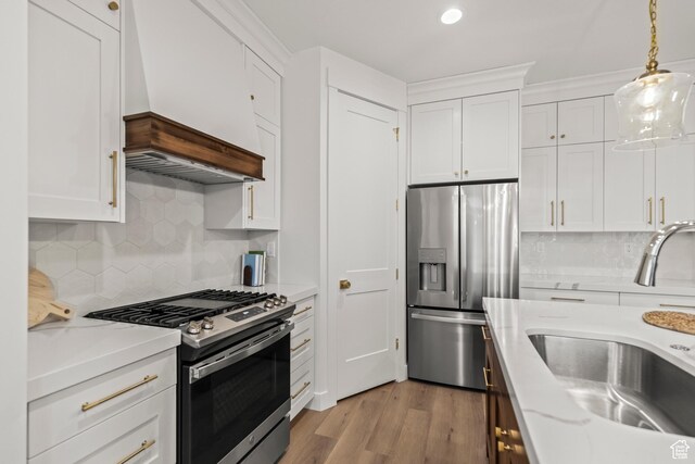 949 W Torrey Pines Dr, Richfield, UT 84701 - kitchen featuring white cabinets, a sink, decorative backsplash, appliances with stainless steel finishes, and premium range hood