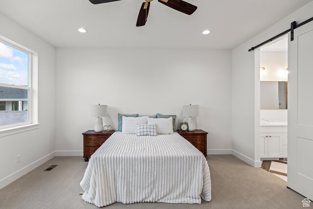 949 W Torrey Pines Dr, Richfield, UT 84701 - bedroom featuring a barn door, visible vents, baseboards, and light carpet