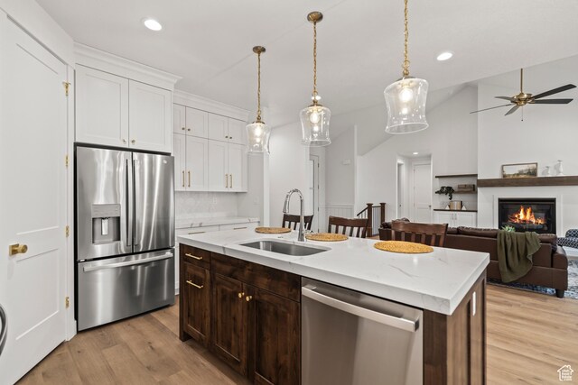 949 W Torrey Pines Dr, Richfield, UT 84701 - kitchen featuring white cabinets, light wood-style flooring, appliances with stainless steel finishes, and a sink
