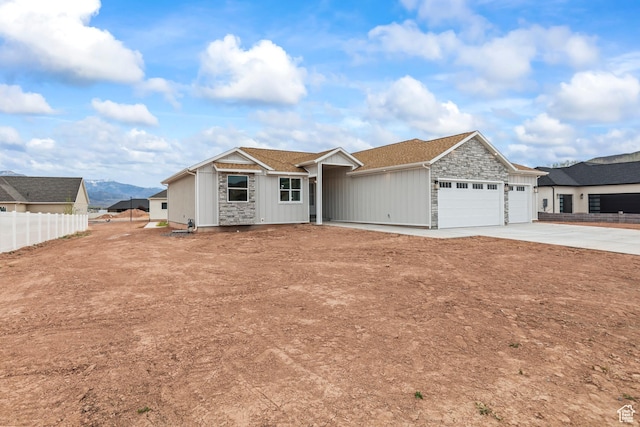 949 W Torrey Pines Dr, Richfield, UT 84701 - ranch-style home featuring concrete driveway, stone siding, board and batten siding, an attached garage, and fence