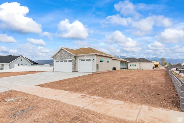 949 W Torrey Pines Dr, Richfield, UT 84701 - view of front of property with a garage, driveway, stone siding, and fence