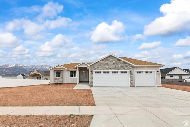 949 W Torrey Pines Dr, Richfield, UT 84701 - ranch-style house with fence, an attached garage, board and batten siding, driveway, and stone siding