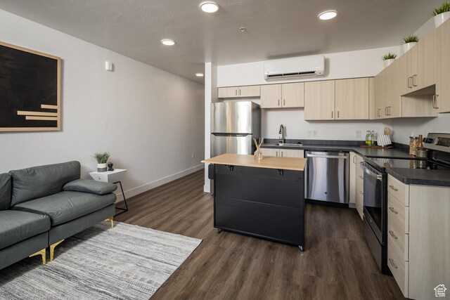 443 W Kane Creek Blvd Unit A206, Moab, UT 84532 - kitchen featuring an AC wall unit, a sink, dark wood-style floors, baseboards, and appliances with stainless steel finishes