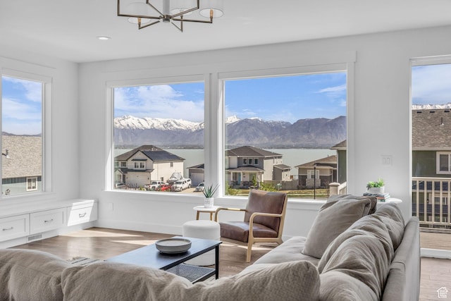 2948 S Puddle Ln, Saratoga Springs, UT 84045 - living area featuring a mountain view, wood finished floors, a notable chandelier, and a healthy amount of sunlight