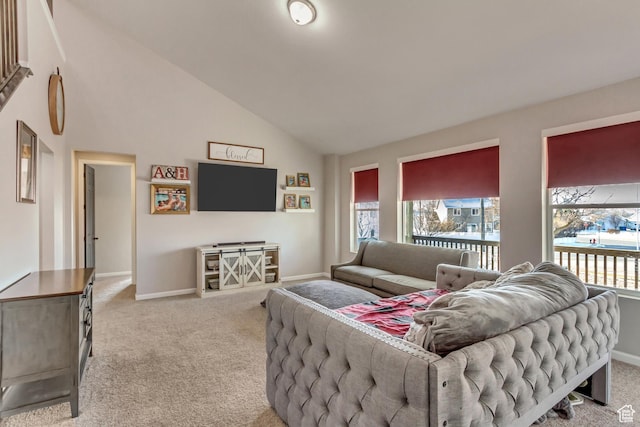 living room featuring high vaulted ceiling, a wealth of natural light, carpet floors, and baseboards
