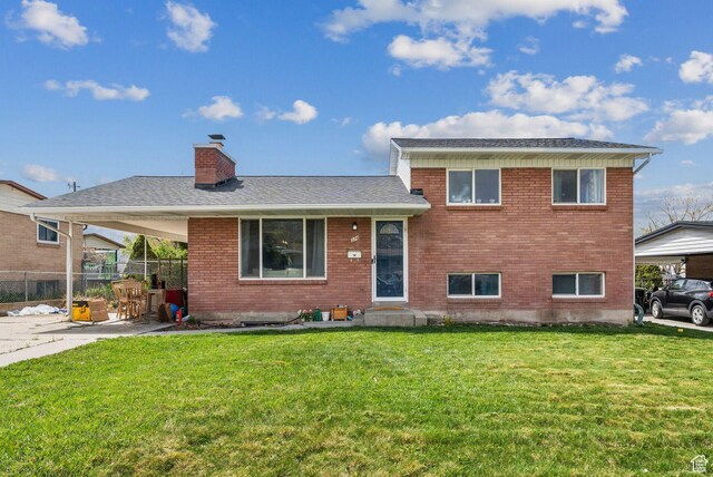 374 S Fairlane, Tooele, UT 84074 - tri-level home with brick siding, a chimney, a front lawn, and fence