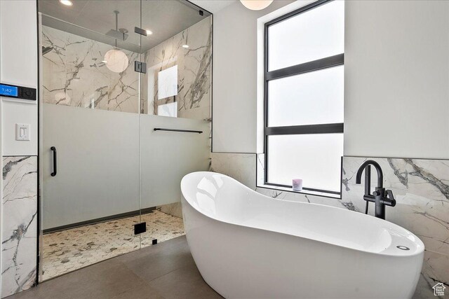 655 Wilard Peak Rd, Mantua, UT 84324 - bathroom with tile walls, a freestanding tub, a marble finish shower, and plenty of natural light
