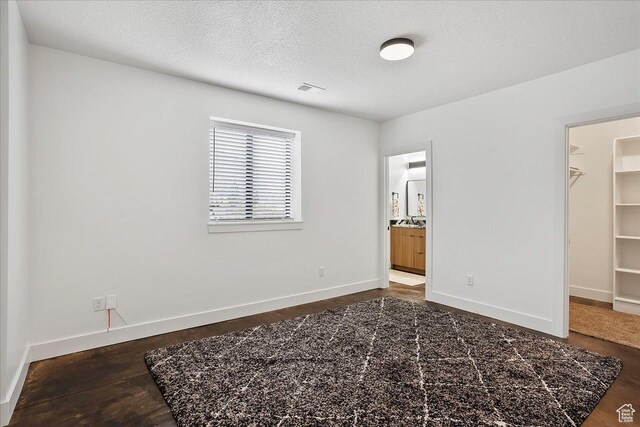 655 Wilard Peak Rd, Mantua, UT 84324 - unfurnished bedroom with a walk in closet, wood finished floors, visible vents, and baseboards