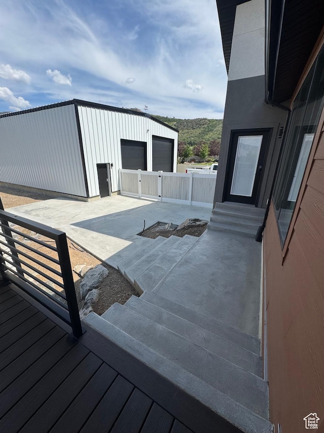 655 Wilard Peak Rd, Mantua, UT 84324 - deck with a detached garage, entry steps, an outdoor structure, and a patio area