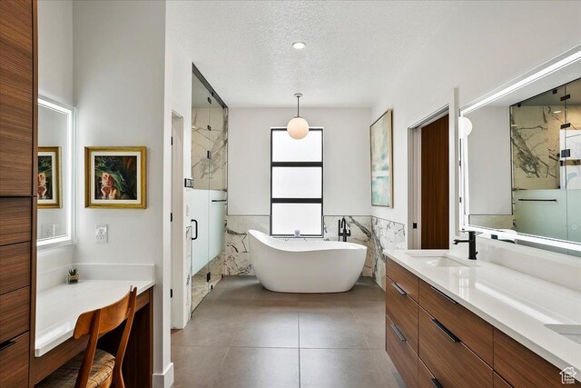 655 Wilard Peak Rd, Mantua, UT 84324 - bathroom featuring a textured ceiling, a marble finish shower, vanity, tile walls, and a soaking tub
