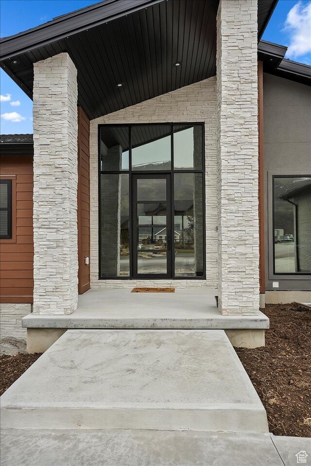 655 Wilard Peak Rd, Mantua, UT 84324 - property entrance with a chimney, stone siding, and covered porch