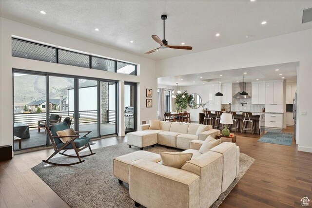 655 Wilard Peak Rd, Mantua, UT 84324 - living room featuring visible vents, recessed lighting, a ceiling fan, a high ceiling, and wood finished floors