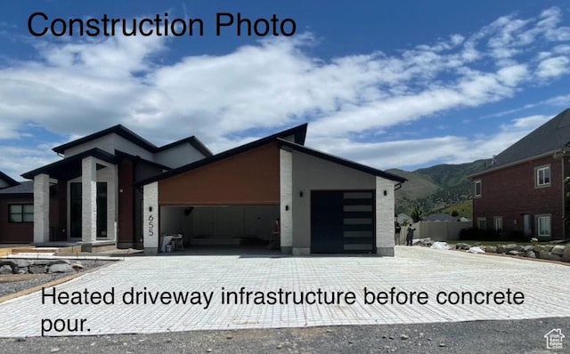 655 Wilard Peak Rd, Mantua, UT 84324 - view of front of house featuring a garage, a mountain view, and decorative driveway