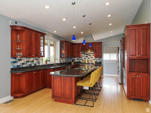 1022 E Northbonneville Dr N, Salt Lake City, UT 84103 - kitchen featuring reddish brown cabinets, backsplash, freestanding refrigerator, light wood-style flooring, and recessed lighting