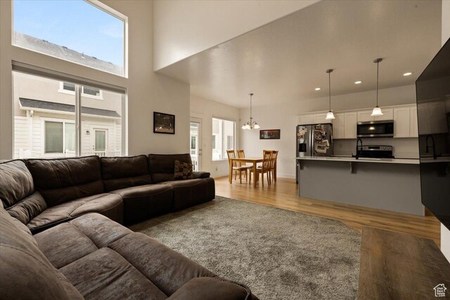 269 W 590 N, Vineyard, UT 84059 - living area with a chandelier, light wood finished floors, a towering ceiling, and recessed lighting