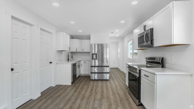 557 N 1200 W, Salt Lake City, UT 84116 - kitchen with wood finished floors, a sink, white cabinets, appliances with stainless steel finishes, and recessed lighting