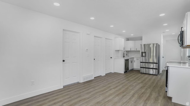 557 N 1200 W, Salt Lake City, UT 84116 - kitchen with stainless steel appliances, a sink, recessed lighting, light wood-style floors, and light countertops