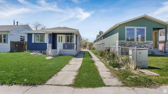 557 N 1200 W, Salt Lake City, UT 84116 - view of front of home featuring a front lawn, stone siding, central AC, a porch, and fence