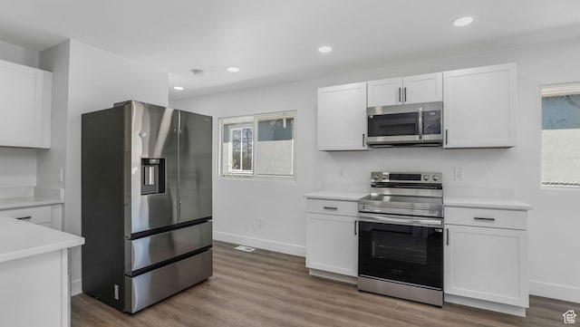 557 N 1200 W, Salt Lake City, UT 84116 - kitchen featuring baseboards, white cabinetry, wood finished floors, light countertops, and appliances with stainless steel finishes