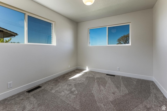 unfurnished room with baseboards, visible vents, and carpet floors