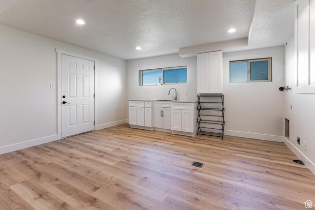 bar featuring recessed lighting, baseboards, a textured ceiling, and light wood-style floors