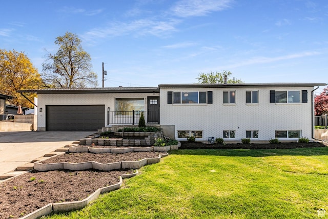 split level home with brick siding, a front lawn, driveway, and a garage